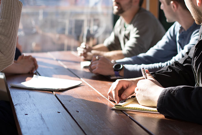 Background image of experts discussing proposal