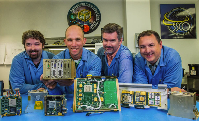 Developers of SpaceCube processors are pictured here with some of the SpaceCube family of products. From left to right: Alessandro Geist; Dave Petrick; Tom Flatley; and Gary Crum. The products include (from left to right): SpaceCube 1.0 and 1.5 prototypes; SpaceCube 2.0 and Mini prototypes; and SpaceCube 1.5 flight unit. (Credit: Bill Hrybyk/NASA)