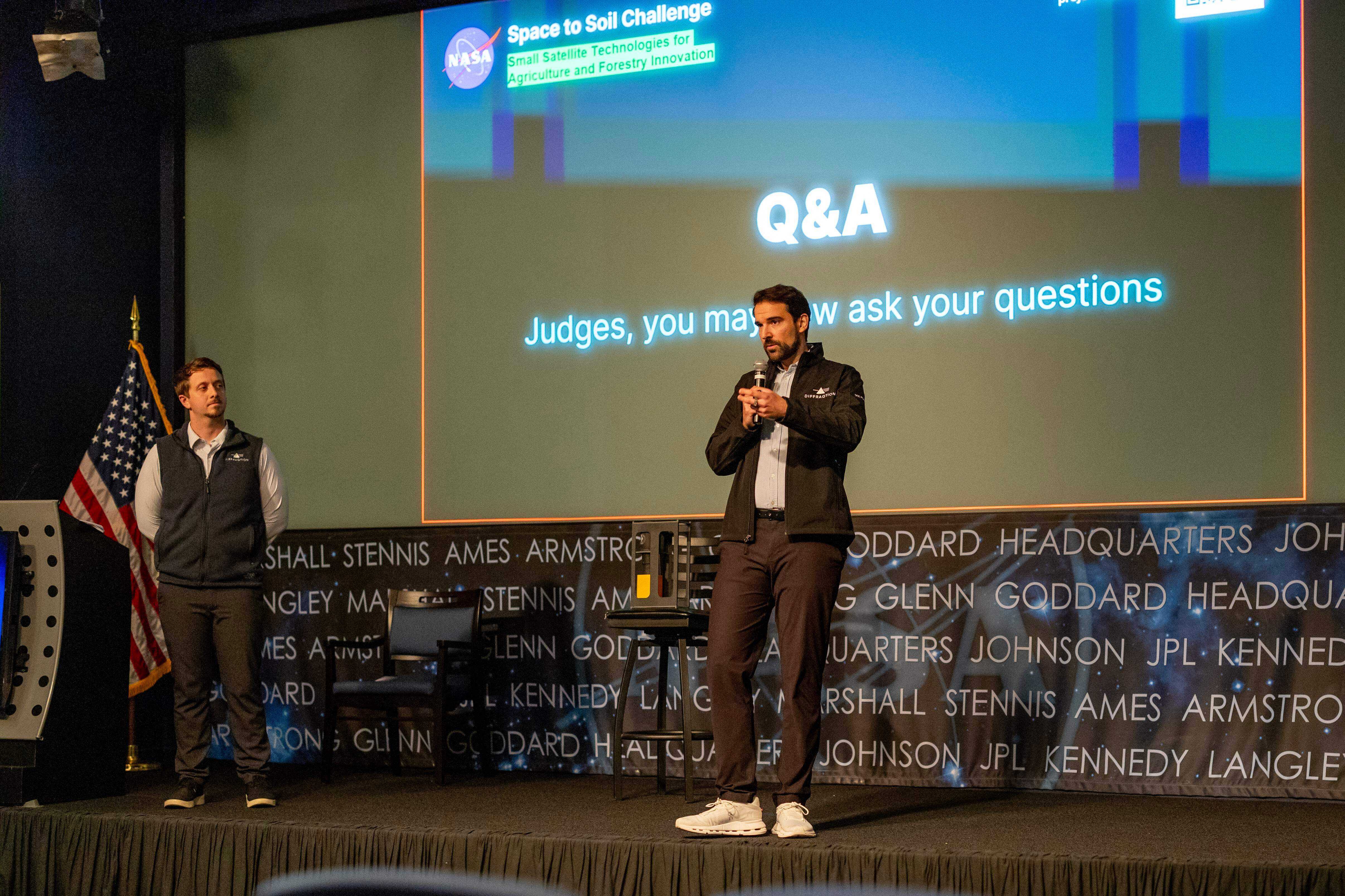 A man on stage giving a presentation in front of a crowd of people.